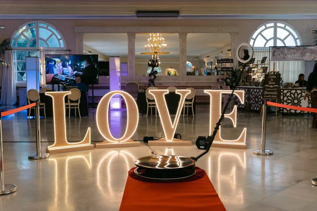 360 platform with a ring light in front of glowing LOVE letters at a wedding