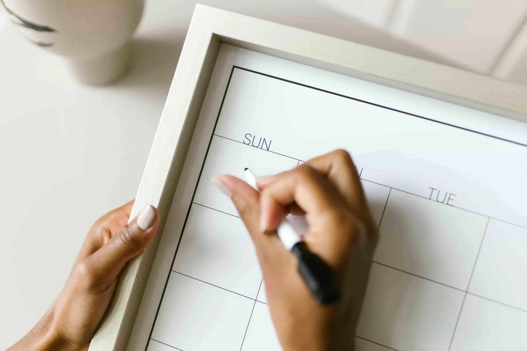 Hand marking event dates on a weekly calendar